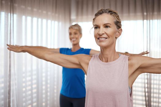 Shot of two mature women exercising together at home.