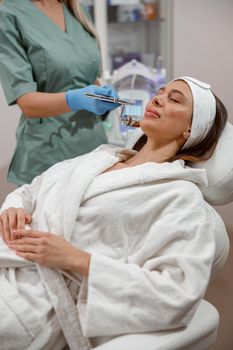 Cosmetologist making aesthetic face treatment in beauty salon. Rejuvenation and hydration.