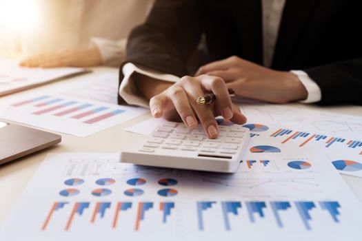 Businesswoman or accoutant calculates financials with graph report on the table on the cost of office