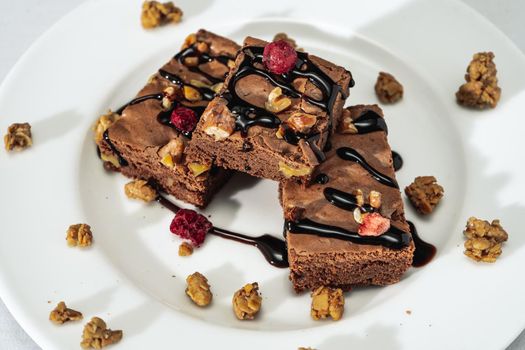 Chocolate brownie squares with walnut pieces, chocolate threads and granola. Natural, healthy food concept. High view.