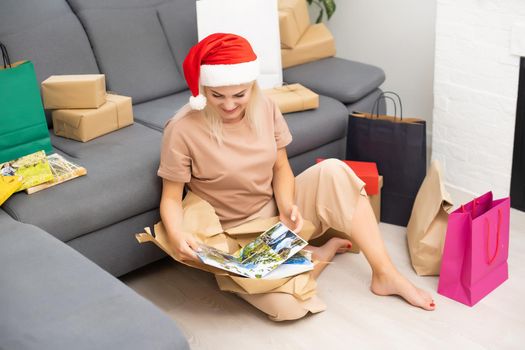 woman holds and unpacks photobook as gift. Present.