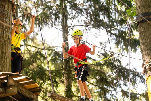 Boy climber walks on the rope bridge