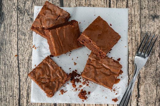 Homemade chocolate brownie squares on a table. Top view.