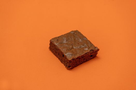 Chocolate brownies on an orange background.