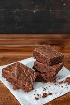 Stack of Homemade chocolate brownie squares on a table. Vertical orientation. Copy space