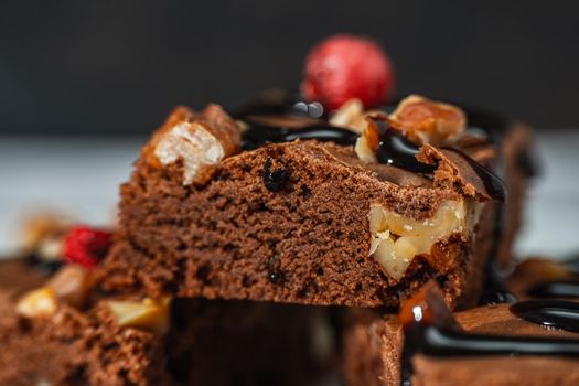 Close-up of homemade chocolate brownies squares with walnut pieces, chocolate strands and granola. Natural, healthy food concept.