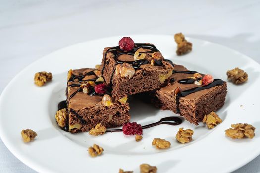 Chocolate brownie squares with walnut pieces, chocolate threads and granola. Natural, healthy food concept. High view.