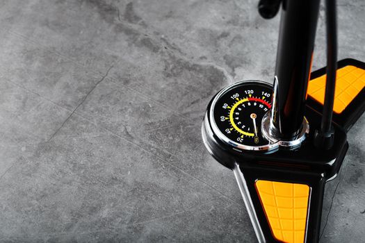 Air pump with a manometer and a wheel inflation hose on a dark background with free space