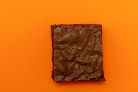 Chocolate brownies on an orange background.