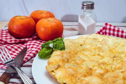 high view of a Spanish potato omelette on a wooden rustic table.