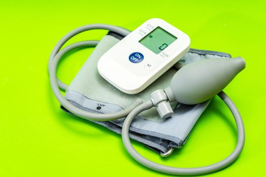 Automatic blood pressure monitor or blood pressure meter on green background. Medical equipment. Medical technology.