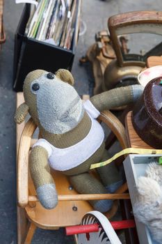 London, UK - 17 June 2019, Knitted monkey in a vest sits on a high chair on display Spitalfields vintage market