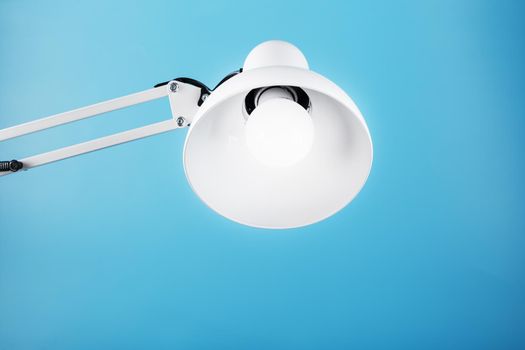 White table office lamp on blue background with space for text and idea concept