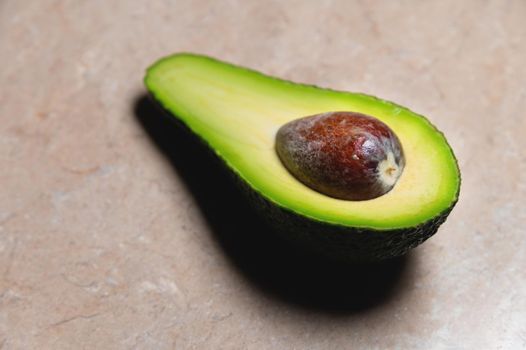 Close-up Fresh vegetables - Zutano avocado on table with a black background. Contrasting image of a tasty vegetable.