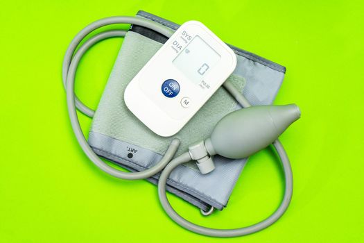 Automatic blood pressure monitor or blood pressure meter on green background. Medical equipment. Medical technology.