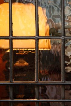 Lampshade through vintage corrugated glass window in pub