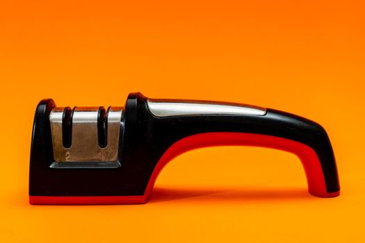 Knife sharpener isolated on an orange background.