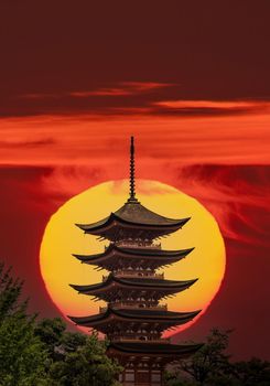 Composition of Japanese pagoda and huge sun in the background with text space