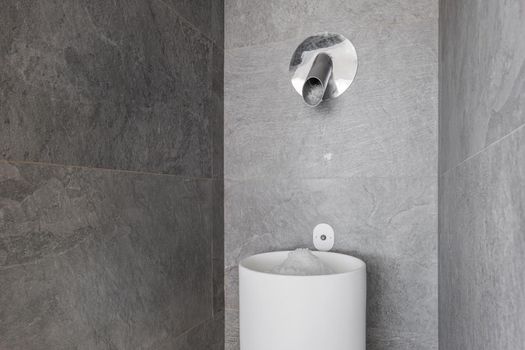 Ice maker in a modern sauna with gray marble walls in wellness spa center