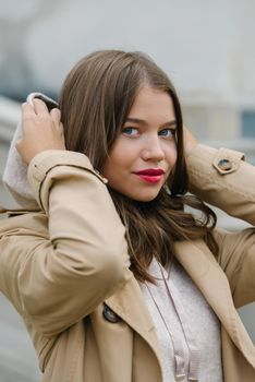 Portrait of fashionable women in beige sports suit and trench coat posing. street look fashion