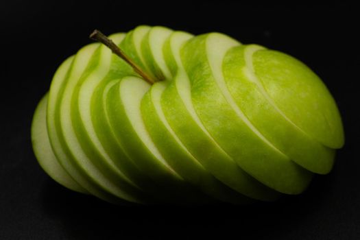 Fresh green apple and sliced isolated on black background art abstract concept.