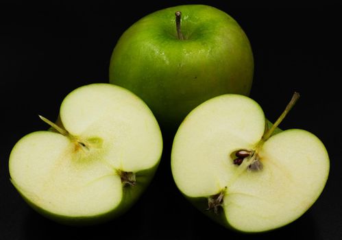 Fresh green apple and sliced isolated on black background art abstract concept.