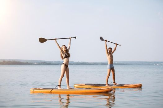 happy young couple standing on the sapboards. concept of ecotourism.