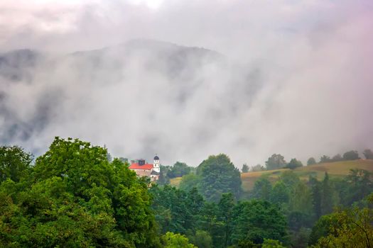 beauty mountain landscape with alone building and mist over the mountain