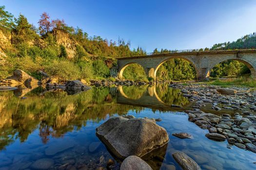 amazing view of the peaceful river and old stone bridge	 