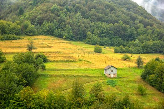 Alone old wooden house on a hill in a mountain. Idyllic view