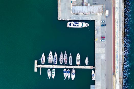 Top View by drone of yachts and small motor boats on the harbor. Yacht and sailboat are moored at the quay. 