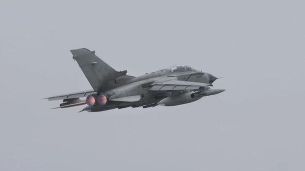 Andravida Greece APRIL, 1, 2022 NATO ground attack military jet aircraft in flight with full afterburner in grey bad weather sky. Panavia Tornado IDS ECR of Italian Air Force