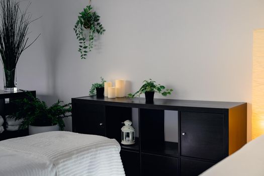 Interior of the massage room of a beauty clinic. Clean and relaxing atmosphere, massage table with towels, plants and candles and decoration. Horizontal