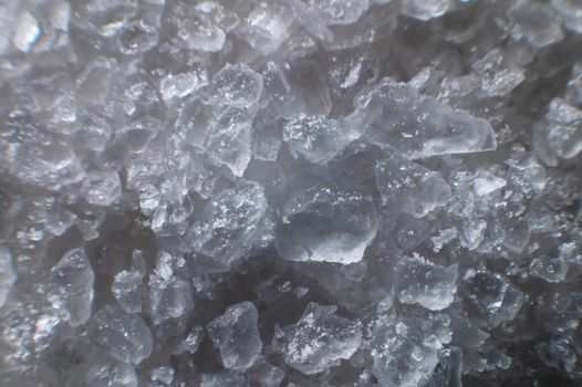 Coarse white iodized salt. Detailed background texture Macro close-up. Salt crystals of different sizes.