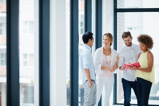 Shot of a group of colleagues having a conversation in the office.