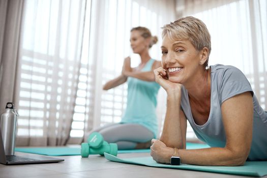 Shot of two mature women exercising together at home.