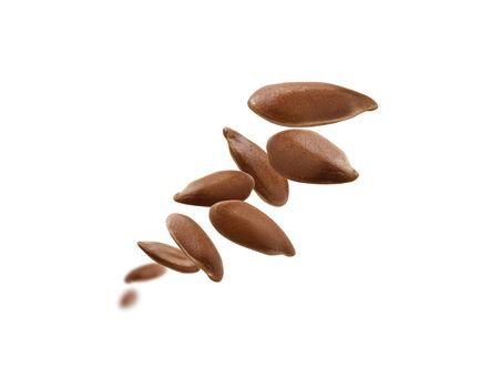 Flax seeds are levitated on a white background.
