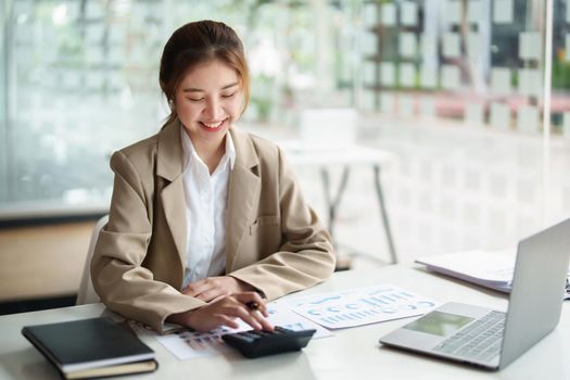 accountant, Auditor, Self-Employed, Finance and Investment, tax calculation and budget, Portrait of Asian female entrepreneur using a calculator to calculate. Company business results document