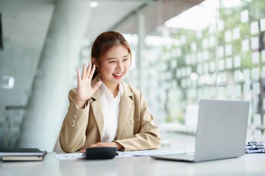 Data analysis, roadmap, marketing, accounting, auditing. Portrait of Asian businesswoman using computer in video conferencing, presenting marketing plan using statistical data sheet at work