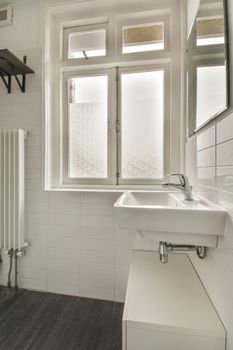 The interior of the bathroom in white of a modern house with sink and window