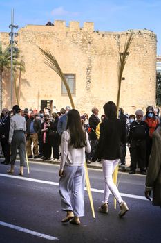 Elche, Alicante, Spain- April 10, 2022: People with white palms for the Palm Sunday of the Holy Week of Elche