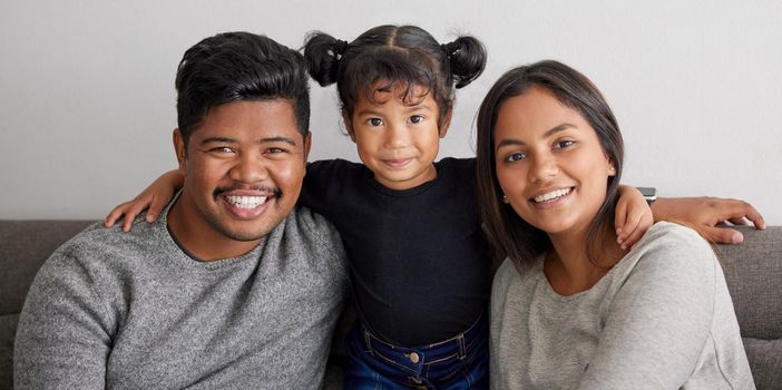 Shot of a mother and father bonding with their daughter.