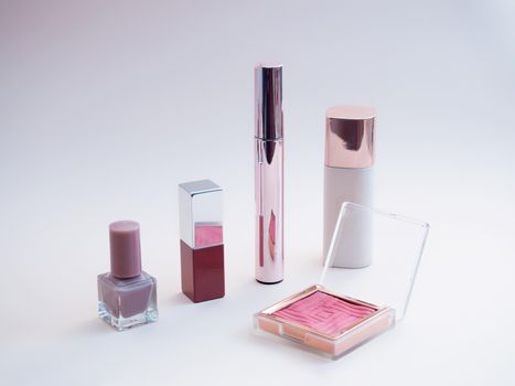 set of beauty cosmetics for female face and eye makeup on pink background . photo