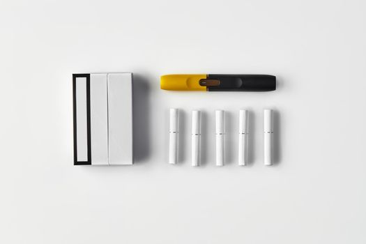 New generation black and yellow electronic cigarette, one pack and five heatsticks, isolated on white. New technology. Heating tobacco system. Template place for your text, image. Close up, flat lay