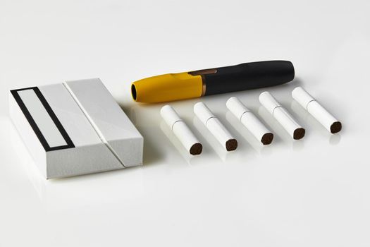New generation black and yellow electronic cigarette, pack and five heatsticks, isolated on white. New technology. Tools used to help stop smoking. Heating tobacco system. Advertising area. Close up