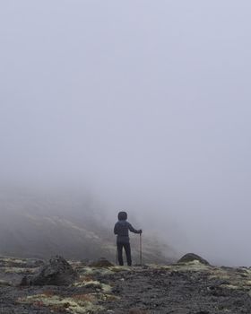 A young girl in the mountains goes into the clouds. dense clouds. photo