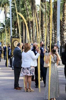 Elche, Alicante, Spain- April 10, 2022: People with white palms for the Palm Sunday of the Holy Week of Elche