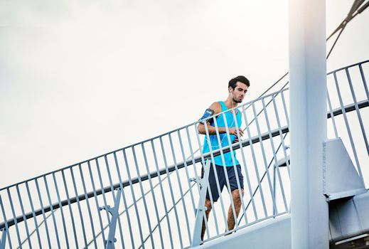 Low angle shot of a handsome young man working out in the city.