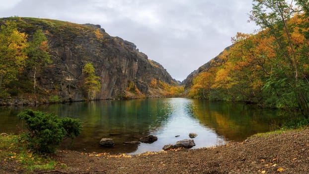 Emerald lake in the Khibiny mountains. Lake with emerald water with rocky shores. photo