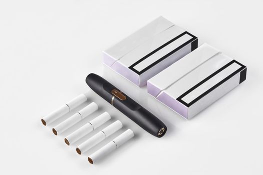 New generation black electronic cigarette, two packs with purple sides and five heatsticks isolated on white. Heating tobacco system. Hybrid between analog and electronic. Close up, copy space